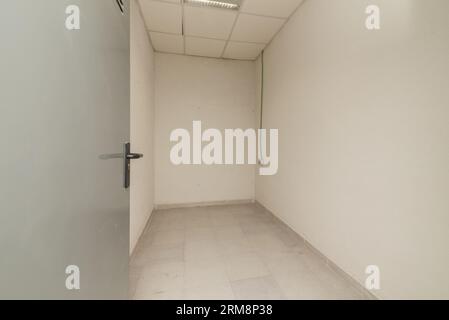 A small empty storage room with technical ceilings and gray ceramic floors Stock Photo