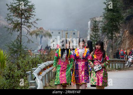 Lũng Cú, Vietnam - January 28th 2020:  Three young women of the Hmong ethnic minority wearing beautiful, colorful dresses to celebrate spring festival Stock Photo