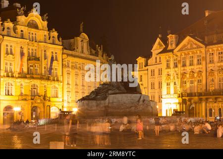 Prague, Czech Republic - July 25th 2016: Tourists around the Jan Hus monument on the Old Town Square at night, surrounded by illuminated buildings Stock Photo