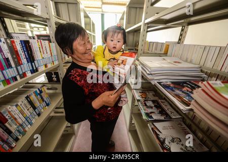 (140508) -- TONGXIANG, May 08, 2014 (Xinhua) -- A woman reads magazine with her granddaughter at a high-class community service center for the elderly in Yongle Village of Tongxiang City, east China s Zhejiang Province, May 8, 2014. A high-class nursing home is put into use here on Thursday, which will benefit senoirs among local residents and migrant workers. (Xinhua/Xu Yu) (zgp) CHINA-ZHEJIANG-COMMUNITY SERVICE FOR THE ELDERLY (CN) PUBLICATIONxNOTxINxCHN   Tong Xiang May 08 2014 XINHUA a Woman reads Magazine With her granddaughter AT a High Class Community Service Center for The Elderly in Y Stock Photo