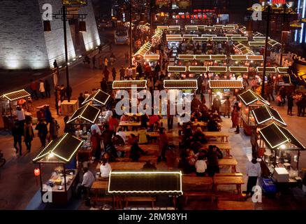 (140513) -- BEIJING, May 13, 2014 (Xinhua) -- Photo taken on Feb. 18, 2014 shows a night food bazaar in Kaifeng City, central China s Henan Province. One of the most popular types worldwide, Chinese food is famous for its taste and variety, with an unparalleled range of ingredients, techniques, dishes and eating styles. The history of Chinese food stretches back for thousands of years and has changed from period to period and in each region according to climate, tradition and local preferences. Chinese people pride themselves on eating a wide variety of foods while remaining true to the spirit Stock Photo