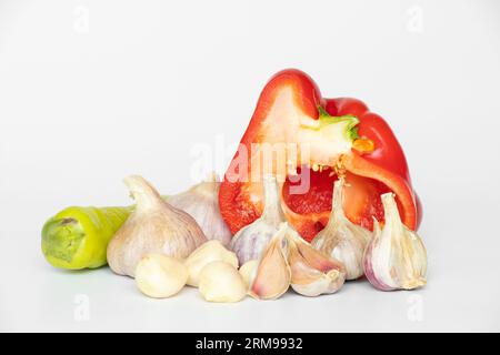 Red and green peppers and garlic lie on a white background close-up Stock Photo