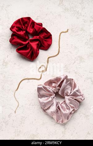 Silk scrunchies and necklace on pink background Stock Photo - Alamy