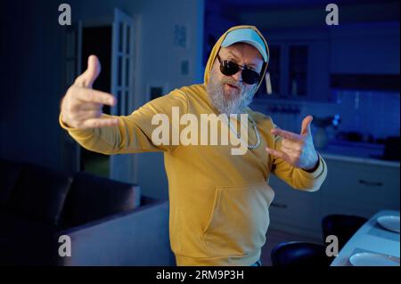 Funky senior man in modern casual clothes dancing for camera Stock Photo