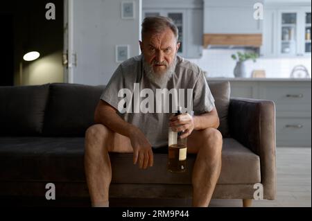 Drunk senior man looking at camera with angry rage emotion on face Stock Photo