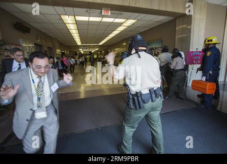 (140529) -- LOS ANGELES, May 29, 2014 (Xinhua) -- Members of Special Enforcement Bureau evacuate the County staff at Los Angeles County Hall of Administration during a training exercise involving a simulated shooting in downtown Los Angeles, the United States, on May 28, 2014. The Los Angeles County Sheriff s Department held a large-scale training exercise involving a simulated shooting taking place at a Board of Supervisors meeting here Wednesday. (Xinhua/Zhao Hanrong) (zjl) U.S.-LOS ANGELES-SHOT-TRAINING EXERCISE PUBLICATIONxNOTxINxCHN   Los Angeles May 29 2014 XINHUA Members of Special Enfo Stock Photo
