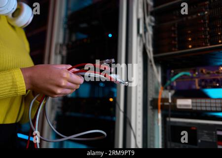 Closeup female IT engineer hands holding internet cables Stock Photo