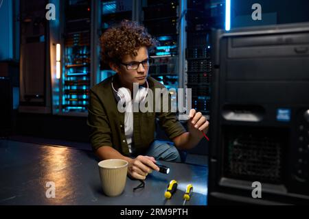 Young IT technician repairing computer in modern data center Stock Photo
