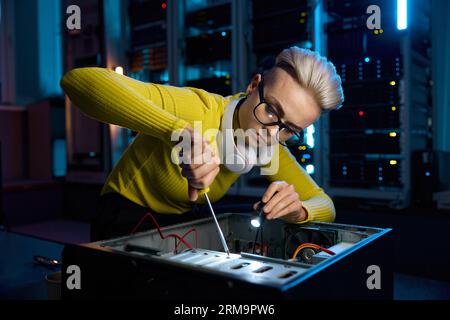 Young IT woman repairing computer system unit using screwdriver Stock Photo
