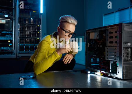Young IT technician taking break drinking coffee in serve room Stock Photo