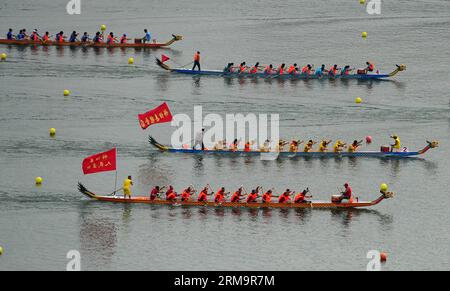 (140530) -- ZIGUI, May 30, 2014 (Xinhua) -- Dragon boat teams compete in the dragon boat race ahead of the Dragon Boat Festival in Zigui County of Yichang City, central China s Hubei Province, May 30, 2014. The Dragon Boat Festival, which falls on June 2 this year, is believed to be designed to commemorate the death of Qu Yuan, a patriot poet during the Warring State Period (475-221 BC). As the festival approaches, people in Zigui County, hometown of Qu Yuan, held dragon boat races for celebrations. (Xinhua/Hao Tongqian) (zwy) CHINA-HUBEI-ZIGUI-DRAGON BOAT FESTIVAL-DRAGON BOAT RACE (CN) PUBLIC Stock Photo