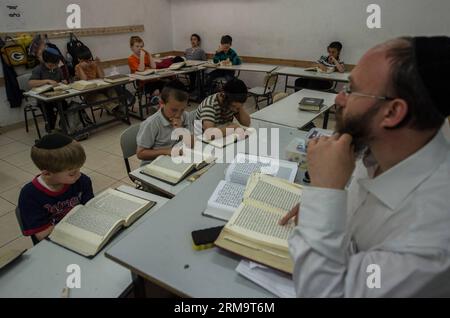 Orthodox Jewish pupils take a class of Jewish religion at Torat Moshe elementary school in Beit Shemesh, about 20 km from Jerusalem, on May 29, 2014. Tzviel Noyman is an Israeli Ultra-Orthodox boy in a family with six children, three boys and three girls. He is ten years old this year and a grade three pupil of Torat Moshe elementary school, which is only opened to Jewish children. Tzviel has eight classes each day, including Hebrew, English, mathematics and Jewish religion, which has four classes each day including Talmud, Mishnah and Gemara. Tzviel likes the religion class best because he th Stock Photo