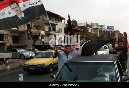 (140603) -- DAMASCUS, June 3, 2014 (Xinhua) -- Syrian supporters of presidential candidate Bashar al-Assad wave national flags with portraits of him during a march in Damascus, capital of Syria, on June 3, 2014. Syria s Higher Judicial Committee has extended the presidential voting period for another five hours until midnight Tuesday, according to the official SANA news agency. (Xinhua/Bassem Tellawi) SYRIA-DAMASCUS-PRESIDENTIAL ELECTIONS PUBLICATIONxNOTxINxCHN   Damascus June 3 2014 XINHUA Syrian Supporters of Presidential Candidate Bashar Al Assad Wave National Flags With Portraits of HIM du Stock Photo