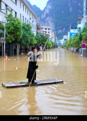 (140604) -- HECHI, June 4, 2014 (Xinhua) -- A man makes his way on a raft along a flooded street in Fengshan County, south China s Guangxi Zhuang Autonomous Region, June 4, 2014. A rainstorm hit Fengsha County on Wednesday, wrecking damage to roads and residences. The downpour has also caused class suspension at some schools. (Xinhua/Zhou Enge) (lmm) CHINA-GUANGXI-FENGSHAN-RAINSTORM-FLOOD (CN) PUBLICATIONxNOTxINxCHN   June 4 2014 XINHUA a Man makes His Way ON a Raft Along a flooded Street in Fengshan County South China S Guangxi Zhuang Autonomous Region June 4 2014 a Rainstorm Hit  County ON W Stock Photo