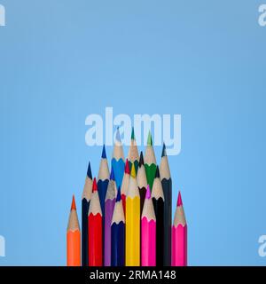 Top view of lots of multicolored pencils. Empty place for text or drawing on the blue background Stock Photo