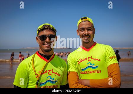 Essaouira, Morocco - August 3, 2023: Two boys at the beach operate as lifeguards at sea. Stock Photo