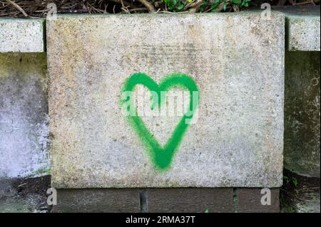 Green heart shape spray painted on concrete Stock Photo