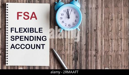 FSA flexible expense account sign on notepad and wooden background Stock Photo