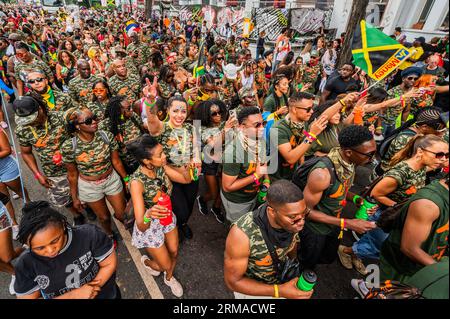 London, UK. 27th Aug, 2023. Dancing behind trucks with big sound systems before the parade - The Sunday of the Notting Hill Carnival, traditionally children's day. The annual event on the streets of the Royal Borough of Kensington and Chelsea, over the August bank holiday weekend. It is led by members of the British West Indian community, and attracts around one million people annually, making it one of the world's largest street festivals. Credit: Guy Bell/Alamy Live News Stock Photo