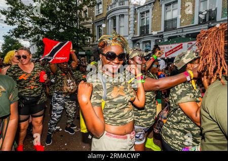 London, UK. 27th Aug, 2023. Dancing behind trucks with big sound systems before the parade - The Sunday of the Notting Hill Carnival, traditionally children's day. The annual event on the streets of the Royal Borough of Kensington and Chelsea, over the August bank holiday weekend. It is led by members of the British West Indian community, and attracts around one million people annually, making it one of the world's largest street festivals. Credit: Guy Bell/Alamy Live News Stock Photo