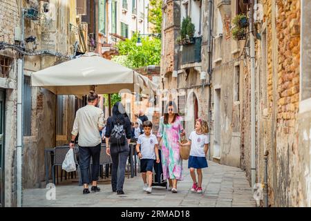 Venice, Italy - May 30 2023: Local scene from the cooblestone streets of Venice. Everyday life in Venice. Stock Photo