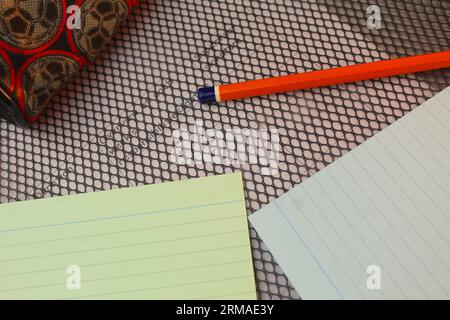 A photo of a school student's flashcards, pencil and pencil case on top of a folder. Stock Photo