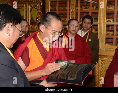 (140707) -- LHASA, July 7, 2014 (Xinhua) -- The 11th Panchen Lama Bainqen Erdini Qoigyijabu (C), who is also the vice president of the Buddhist Association of China (BAC) and a member of the Standing Committee of the Chinese People s Political Consultative Conference (CPPCC) National Committee, looks at scriptures as he visits the Tibet branch of the BAC in Lhasa, capital of southwest China s Tibet Autonomous Region, July 5, 2014. The Panchen Lama visited people from religious groups in Lhasa for the past few days, talking with them and offering head-touching blessings to Buddhist believers. ( Stock Photo