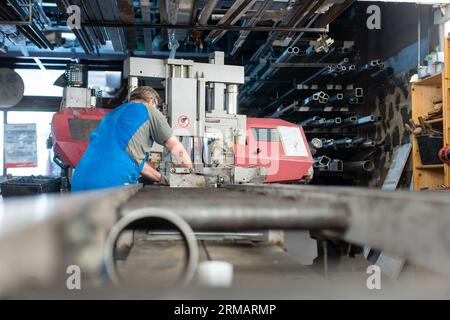 Worker man operating metal saw in his workshop Stock Photo