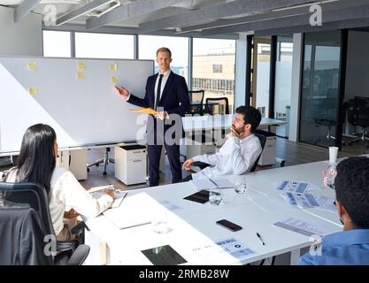 Confident business man professional presenter giving presentation in office. Stock Photo