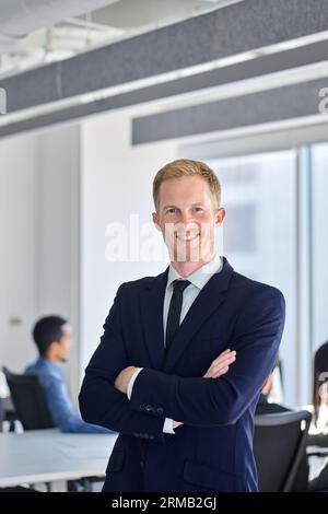 Confident happy young business man team manager standing in office. Vertical Stock Photo