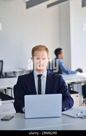 Busy business man manager employee wearing suit using laptop in office. Stock Photo