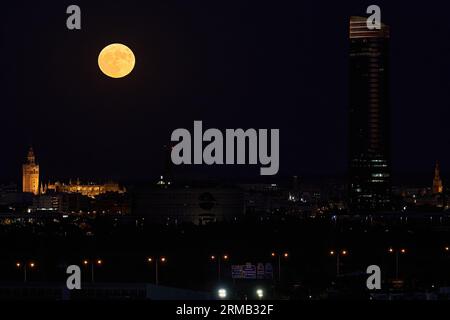 Night of Wonders: Supermoon Illuminates Giralda, Torre Triana, and Torre Pelli in Seville Stock Photo