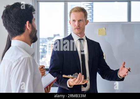 Business man presenter team leader giving presentation in office. Stock Photo
