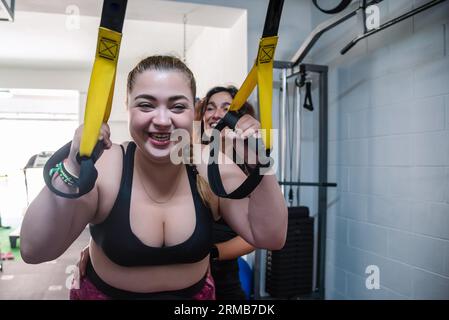 https://l450v.alamy.com/450v/2rmb7dk/young-overweight-girl-training-in-a-gym-and-supervised-by-her-trainer-hanging-from-a-rope-she-is-very-motivated-and-committed-2rmb7dk.jpg