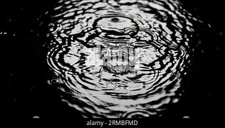 Drop of Water falling into Water, Full Moon Stock Photo