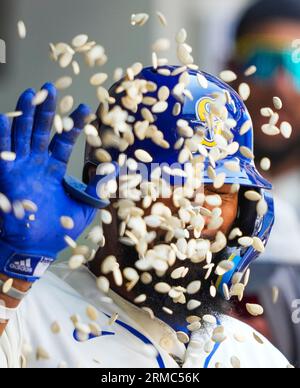 Seattle Mariners' J.P. Crawford (3) holds a trident after hitting a home  run as he is greeted by teammate Teoscar Hernández, left, against the  Kansas City Royals during the first inning of