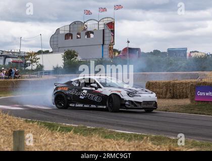 A Raleigh car skids around the race track leaving a plume of tyre smoke at Carfest 2023, Laverstoke Farm, Hampshire. England UK. Stock Photo
