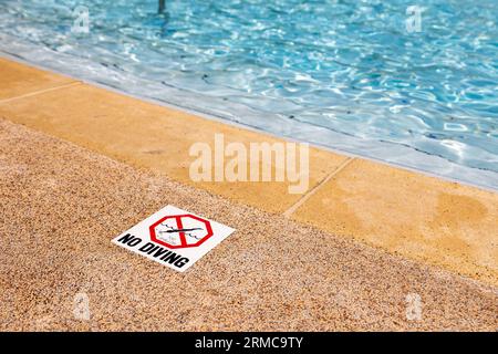Swimming pool edge with warning sign and depth marker Stock Photo