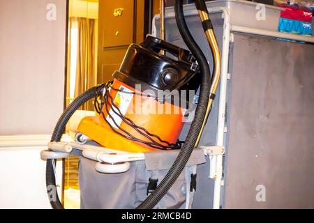 Vacuum cleaner station beside the hotel's room open door. Cleaning hospitality housekeeper's cleaner for carpets cleaning in hotels Stock Photo