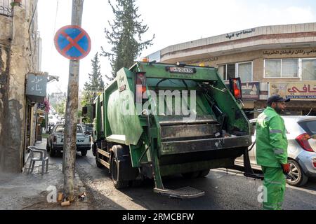 Garbage truck in Amman Jordan, worker in uniform Stock Photo