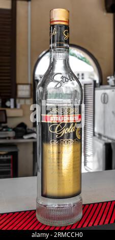 Stolichnaya gold vodka bottle, empty on desk Stock Photo