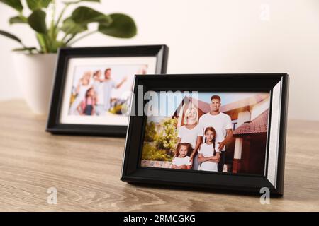 Frames with family photos on wooden table Stock Photo