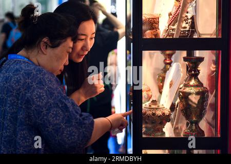 Changchun, China's Jilin Province. 24th Aug, 2023. Visitors buy products from Nepal at the 14th China-Northeast Asia Expo in Changchun, northeast China's Jilin Province, Aug. 24, 2023. Credit: Xu Chang/Xinhua/Alamy Live News Stock Photo