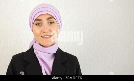 Muslim woman with excitement stands at white studio wall Stock Photo