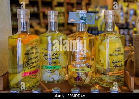 Menton, France - May 26, 2023: Colorful pineapple, ginger, orange vanilla white rum cocktails with fruit in bottles at an artisanal store in Old Town Stock Photo