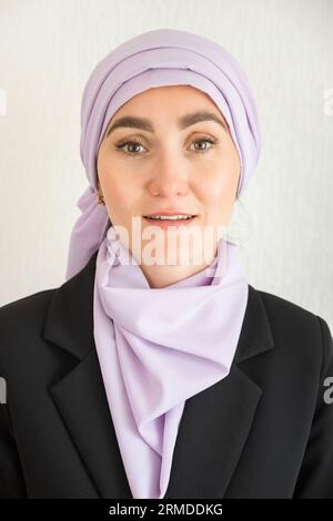 Muslim woman with excitement stands at white studio wall Stock Photo