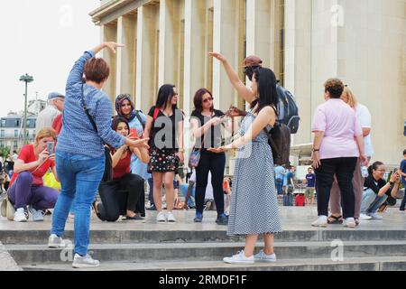 Tourists being photographed 'holding the Eiffel Tower' from the high vantage point of Place du Trocadéro with Paris's best view of the Eiffel Tower Stock Photo