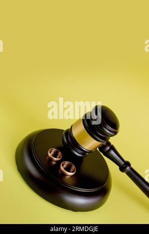Closeup of wedding rings on wooden mallet at table in courtroom. Stock Photo