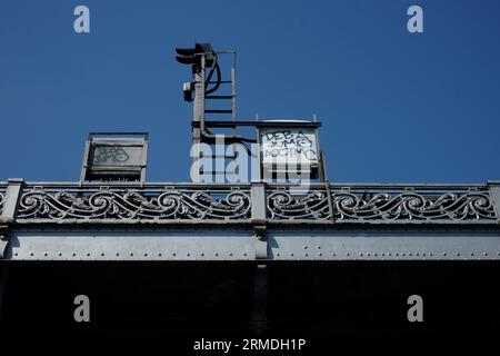 Decorative cast iron balustrade (& train signals) on the upper railway viaduct of Pont de Bir-Hakeim against a blue sky. Camille-Jean Formigé, Paris Stock Photo