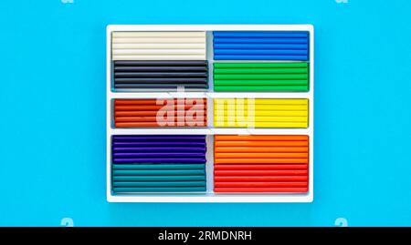 Set of colorful plasticine sticks isolated on a blue background, top view. Stock Photo